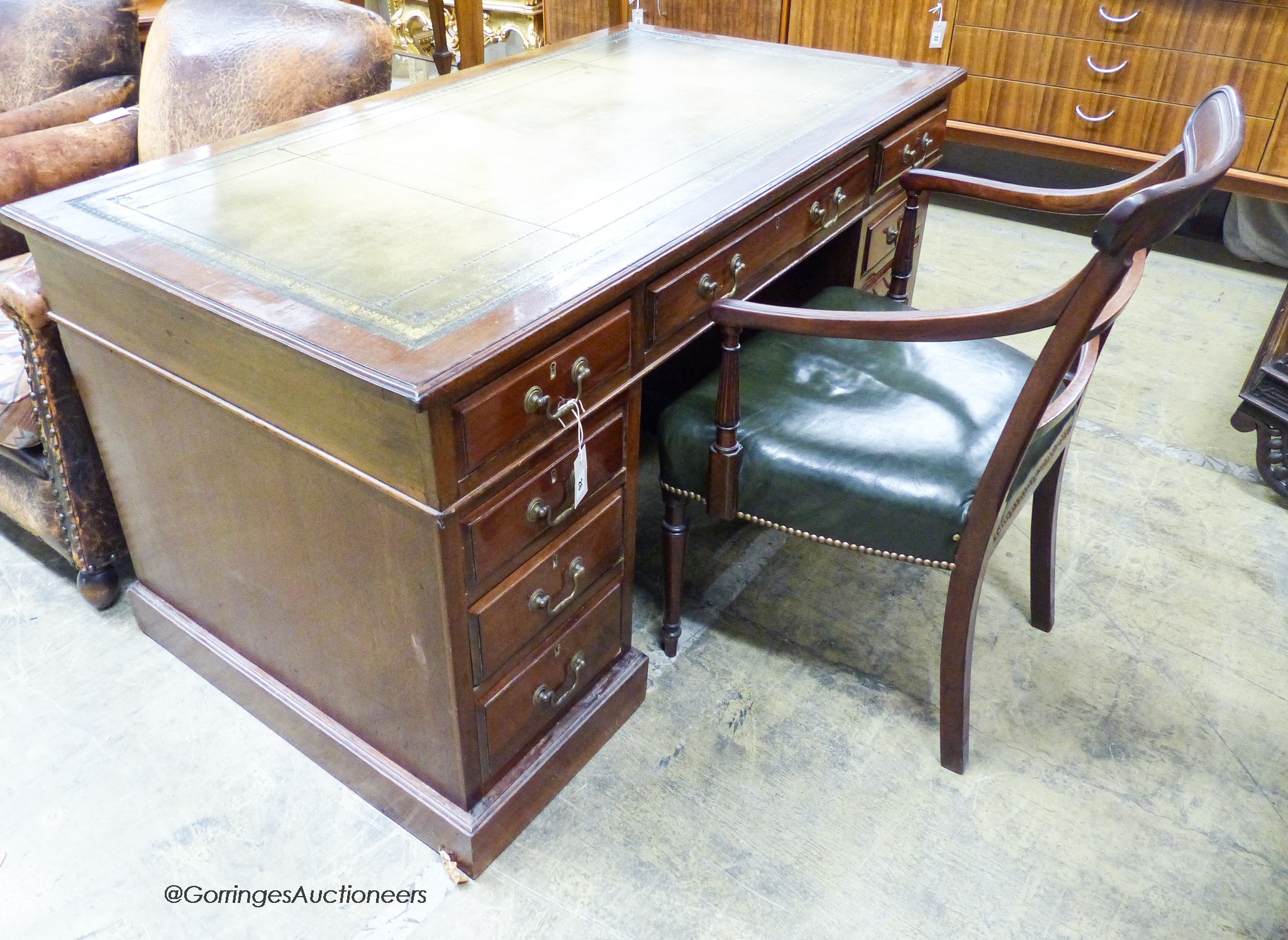 An Edwardian mahogany pedestal desk, length 138cm, depth 75cm, height 74cm together with a George III mahogany elbow chair